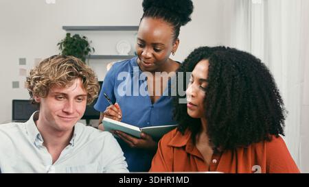Diverse Team Collaboration in Modern Office: Young Startup Trio Discussing Ideas and Plans Stock Photo