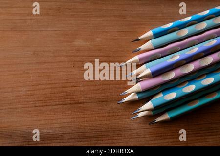 Stacked Polka Dot Pencils on Wood Background Stock Photo