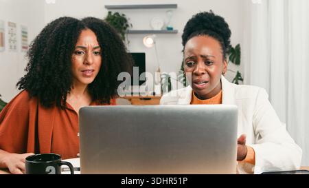 Two Women Collaborating on a Laptop in a Modern Office for a Startup Team Stock Photo