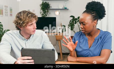 Two Professionals Collaborate During Startup Team Meeting With Tablet In Modern Office Stock Photo