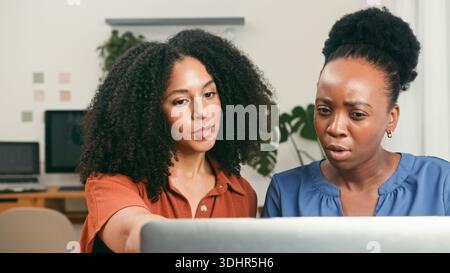 Collaborative Startup Team Working Together on Laptop in a Modern Office Space Stock Photo