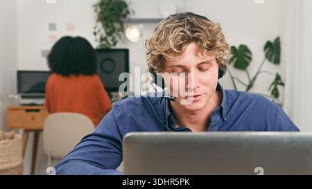 Young Tech Team Collaborating in a Modern Office With Headset and Computer During Day at Workplace Stock Photo