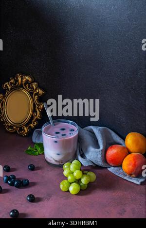 A controlled explosion of color: red fruits in different states—whole, sliced, and pureed—accompanying a watermelon and lime smoothie Stock Photo