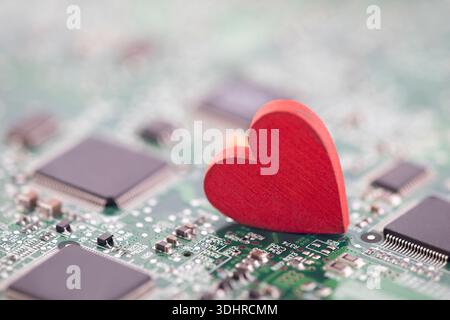 Small red heart on computer circuit board. Internet dating concept. Stock Photo