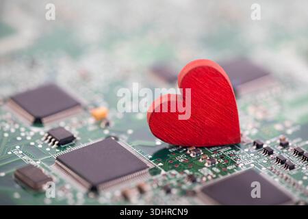 Small red heart on computer circuit board. Internet dating concept. Stock Photo
