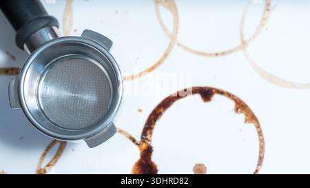 Coffee stains and espresso portafilter on white kitchen surface Stock Photo