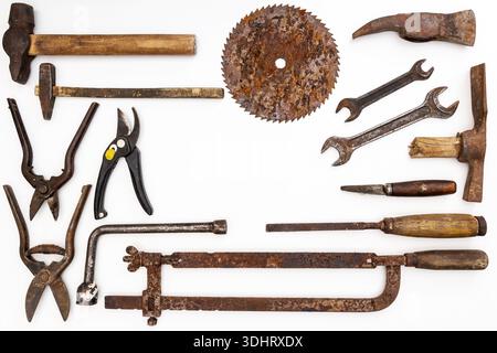 Flat lay of old hand tools on white background. Large collection of various rusty tools and bits arranged on white. Stock Photo