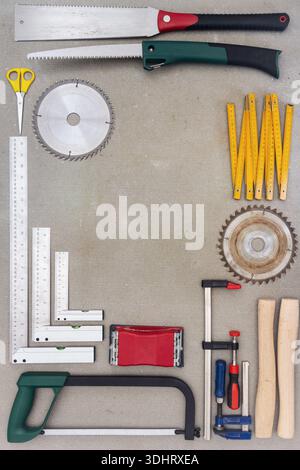 Flat lay of old hand tools on concrete background. Large collection of various rusty tools and bits arranged on concrete. Stock Photo