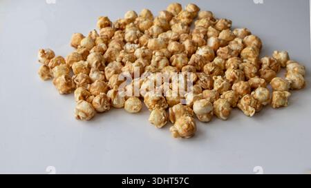Caramel popcorn scattered on white background close perspective Stock Photo