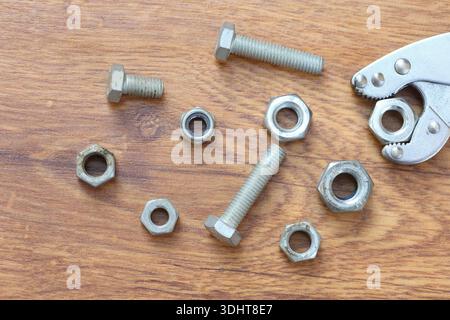 nuts and bolts on a wooden surface Stock Photo