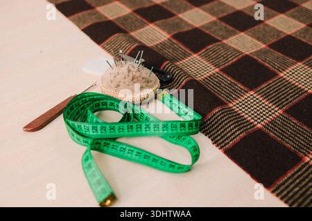 Sewing tools sit on table with fabric, organized for cutting, sewing, and garment creation Stock Photo