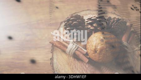 Showing arrangement on wooden table with slice, three cones, tied cinnamon, muffin, printed overlay Stock Photo