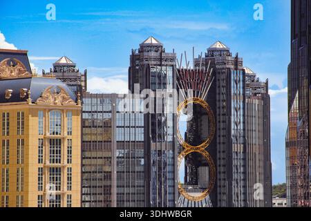 Contemporary urban landscape featuring a mix of neoclassical beige architecture and futuristic dark glass skyscrapers with golden ring accents. Stock Photo