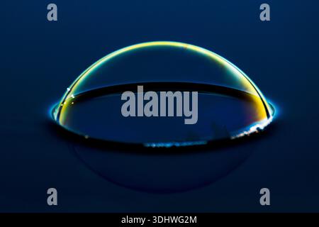 Iridescent Bubble on Dark Water Surface Stock Photo
