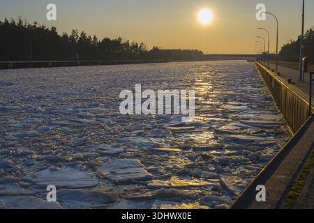 Frozen channel at sunset with reflecting light and wooded banks, ice floes, Elbe-Havel Canal, Jerichower Land, Saxony-Anhalt, Germany Stock Photo
