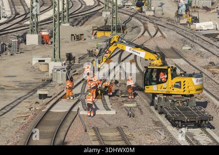 Team of construction workers wearing orange safety equipment working on tracks, Untertuerkheim parking station, Stuttgart, Baden-Wuerttemberg, Germany Stock Photo