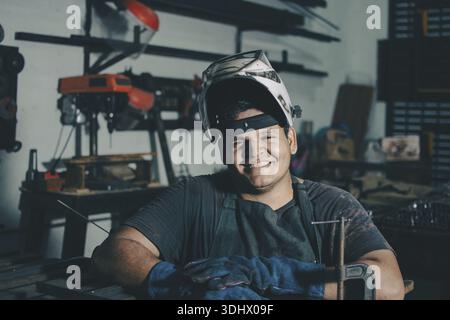 Professional welder smiling at the camera with crossed arms. successful welding worker with arms crossed Stock Photo