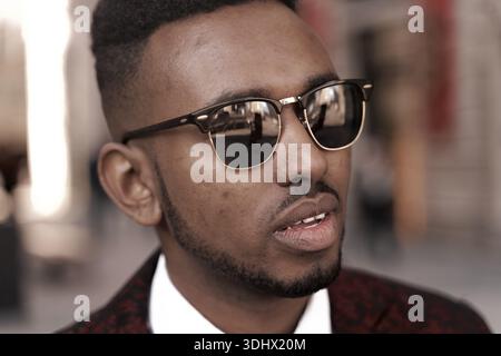 Thoughtful man in sunglasses looking confidently towards the distance, preparedness, troubled, perplexed, perplexedness, challenged, challenge, poised Stock Photo