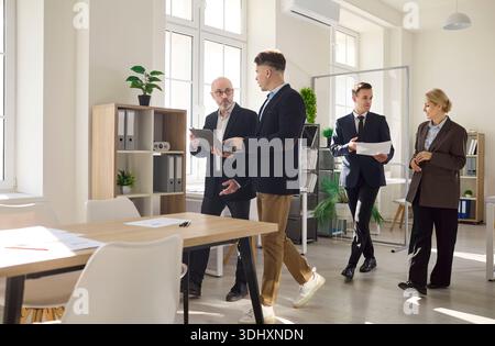 Business team discussing analytics in office, managers reviewing plans and reports Stock Photo