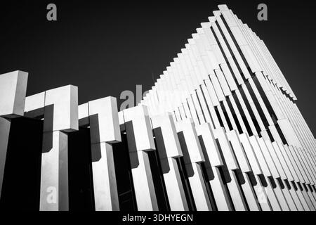 striking example of modernist architecture viewed from a low, upward-looking angle. The building is composed of repeating vertical concrete elements Stock Photo