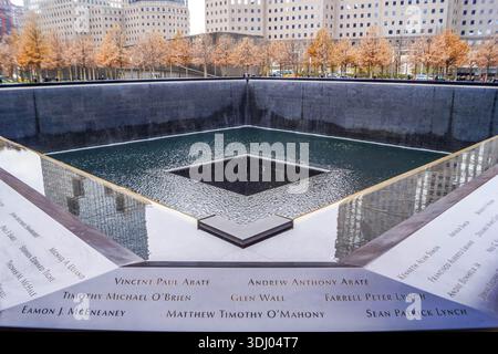 9/11 Memorial reflecting pools with victim names in New York City and Freedom Tower, poignant NYC site of remembrance in American history. Stock Photo