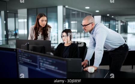 Two Coders Lead Diverse Team Developing Software Solutions In Office. Stock Photo