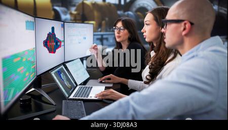 Young Engineers In An Industrial Factory Are Using 3D Software To Perform Maintenance On A Gas Turbine Stock Photo