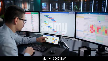 Busy Businessman Managing Multiple Projects On Digital Scheduling Software At Work. Stock Photo