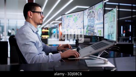 Young Hispanic Man Using CAD Software To Design Commercial Building. Stock Photo