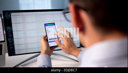 Business Man Coding Invoice On Smartphone App For Tax Audit. Stock Photo