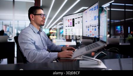 Young Latino Designer Creating User Experience Interface On Computer App Stock Photo