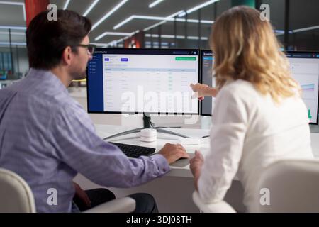 Man And Woman Tracking Supply Chain Logistics On Computer Screen. Stock Photo
