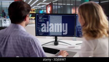 Two Mature Individuals Developing Web Software With Instructor Guidance Stock Photo