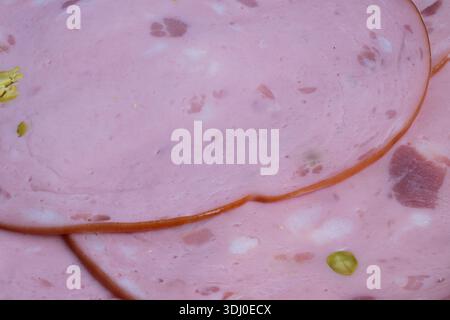pink sausage slices with pistachio detail, editorial food styling flatlay emphasizing color and pattern, soft lighting highlights marbling and nut inc Stock Photo