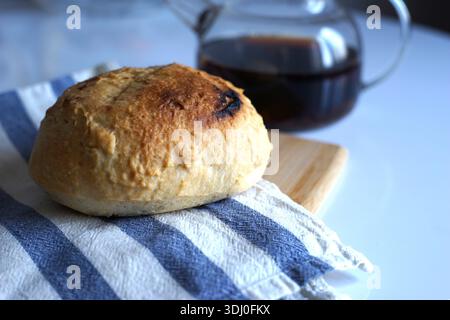Fresh bread on a linen towel on the kitchen table Stock Photo