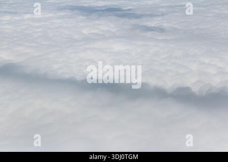 Dramatic and fluffy cloudscape from the airplane's window Stock Photo