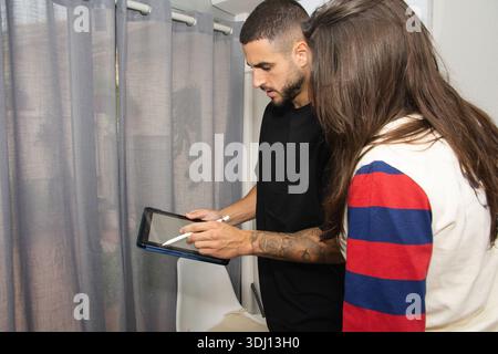 People collaborating on digital tablet using stylus Stock Photo