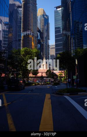 Lau Pa Sat hawker food market in Downtown core Singapore captured amongst the skyscrapers in dramatic morning light. Stock Photo