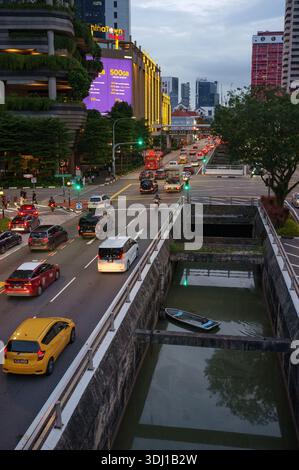A view from the walkway bridge looking towards Upper Pickering street Singapore at dusk with chinatown & canal with a small wooden boat on the water. Stock Photo