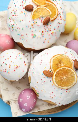 Delicious Easter cakes and eggs on blue table, top view Stock Photo
