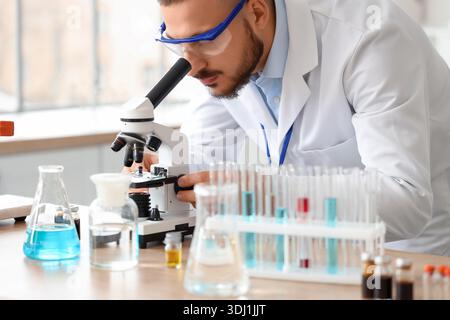 Male scientist looking through microscope in laboratory Stock Photo
