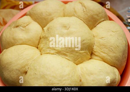 Freshly baked golden yeast buns or Pampushky bread in a bowl. Homemade soft garlic rolls texture. Stock Photo
