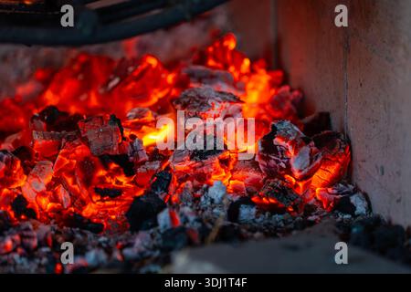 Intense heat from glowing red and orange charcoal embers burning in a fireplace or grill. Stock Photo