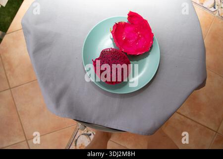 Dragon fruit half and empty peel on pastel plate top view Stock Photo