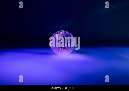 Bitcoin with Golden Glow Reflected on Surface Stock Photo