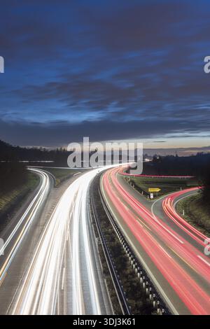 Long-exposure highway at night with light trails and cloudy sky over the countryside, near Stuttgart, Baden-Wuerttemberg, Germany Stock Photo