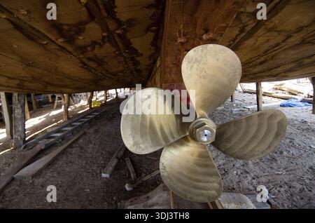The brass propeller of an Omani Dhow- Dhow building is carried out using traditional methods and materials, made primarily from teak and cedar wood us Stock Photo