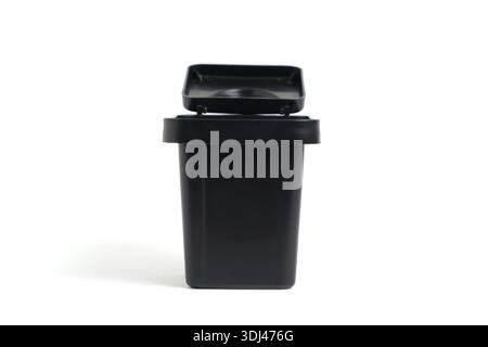 Front view of a small black desktop trash can with an open lid for office waste. Stock Photo