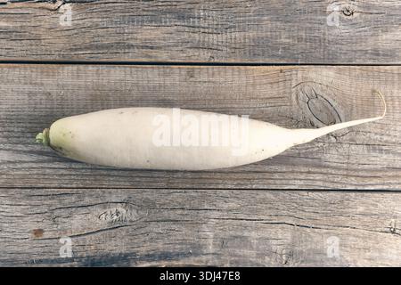 Whole daikon radish on rustic wooden table background Stock Photo