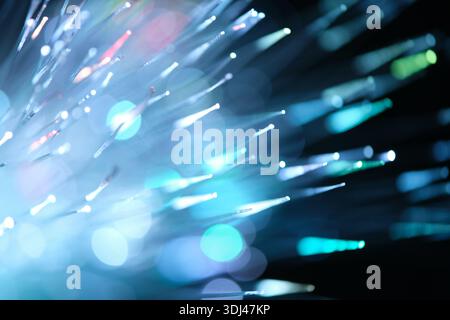 Blue and cyan fiber optic light streaks with soft bokeh, abstract futuristic background representing connectivity and innovation Stock Photo